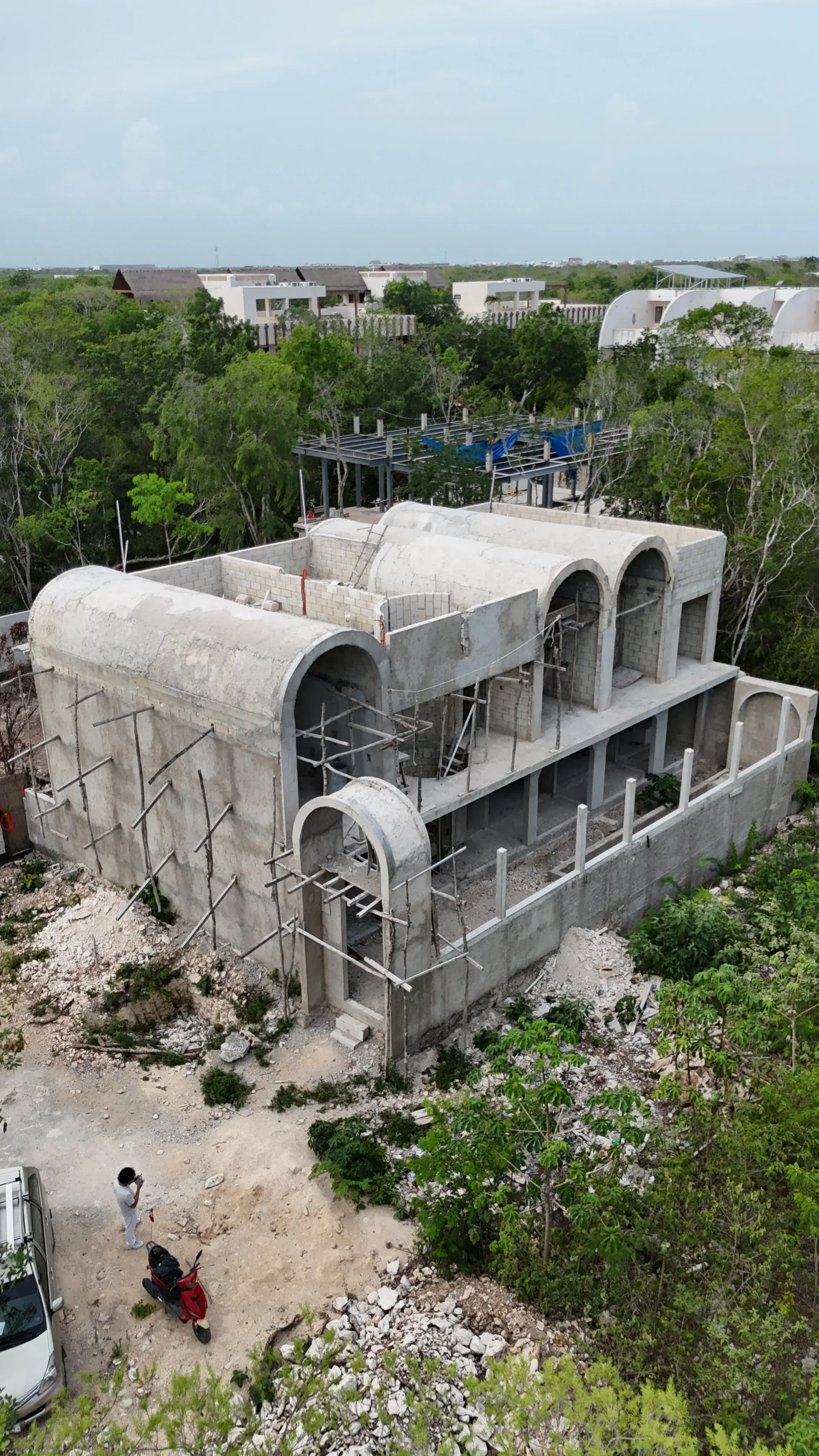 Aerial photograph of the structure under construction, showing the arched openings of the three modules